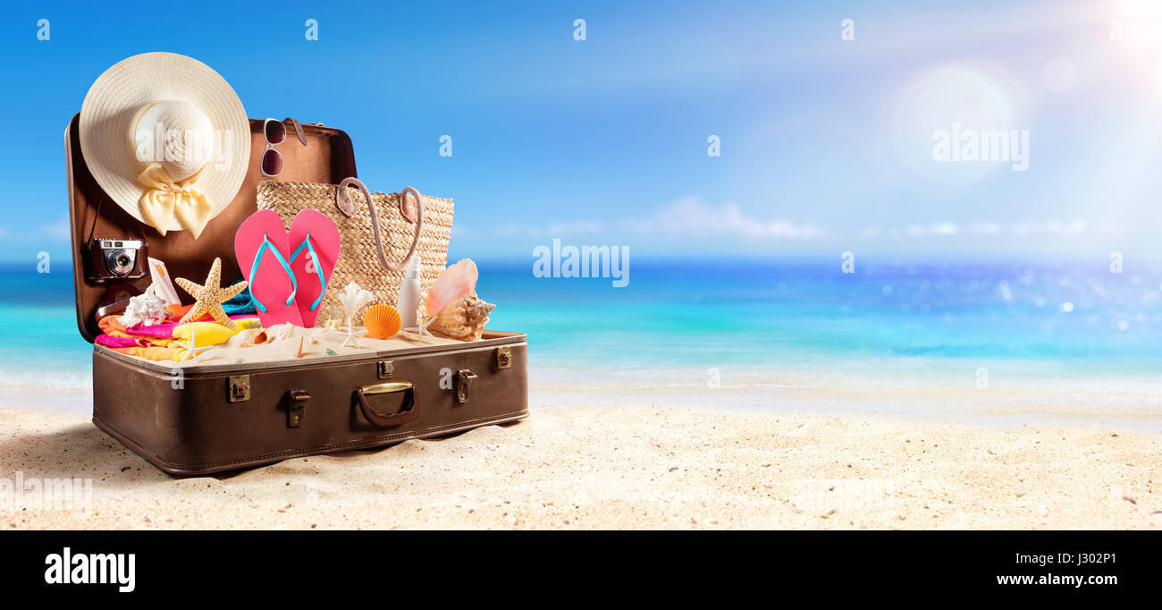 Accessori da spiaggia In valigia sulla spiaggia - Concetto di viaggio Foto Stock
