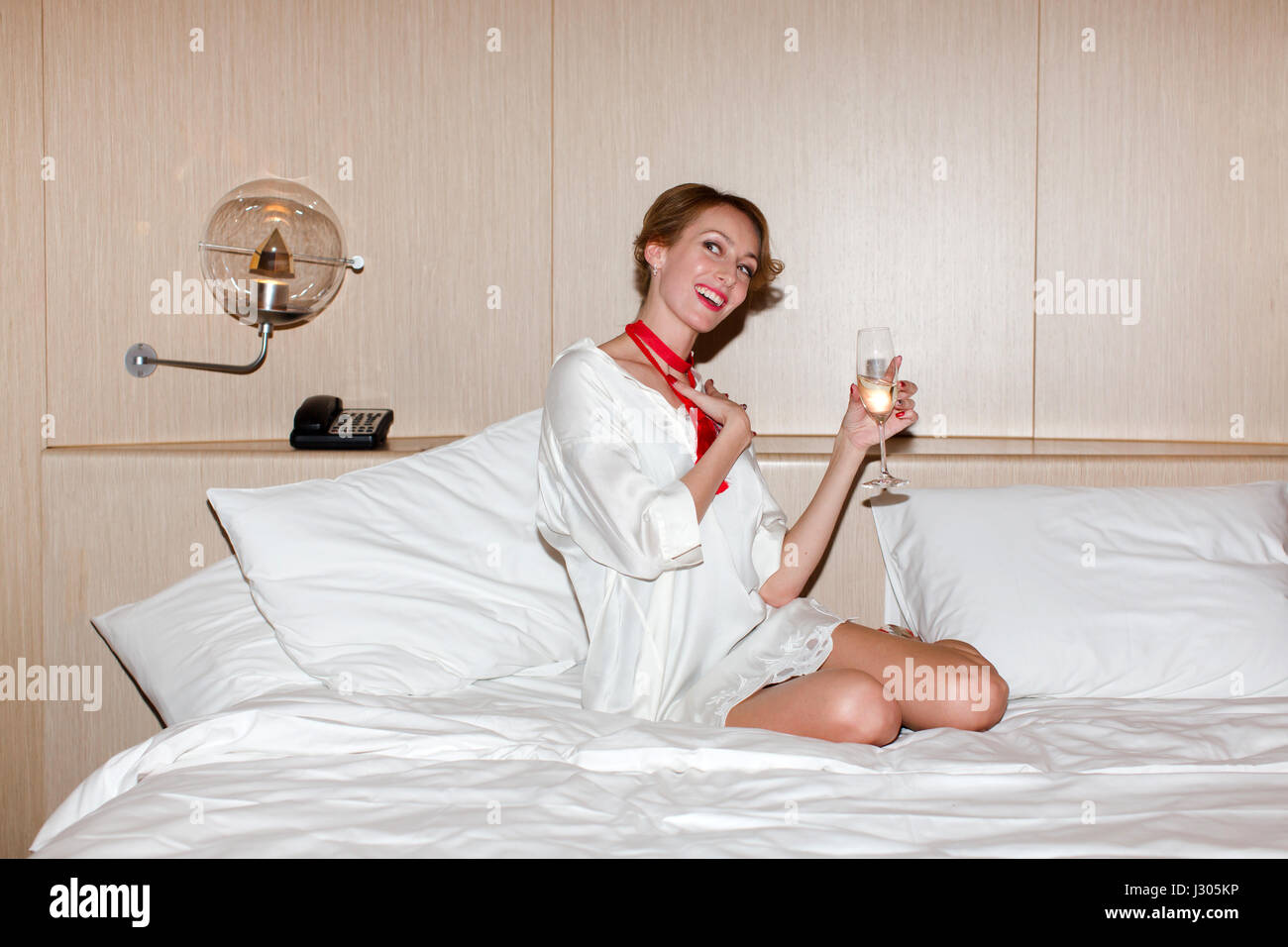 La donna a letto con un bicchiere di sham Foto Stock