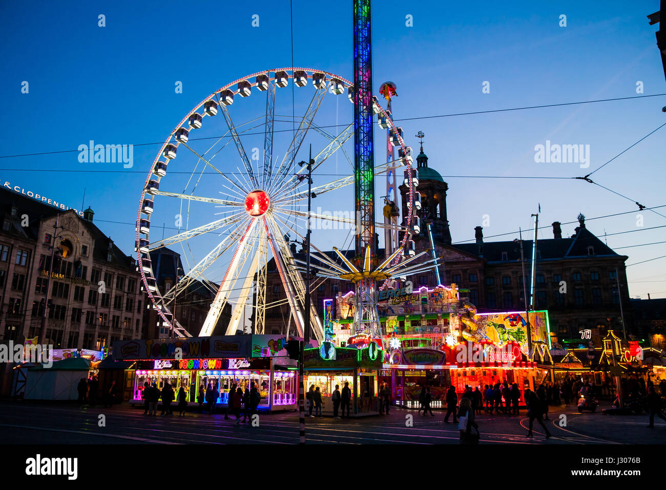 Ruota di traghetti e battenti oscilla su piazza Dam di Amsterdam di notte, Paesi Bassi Foto Stock