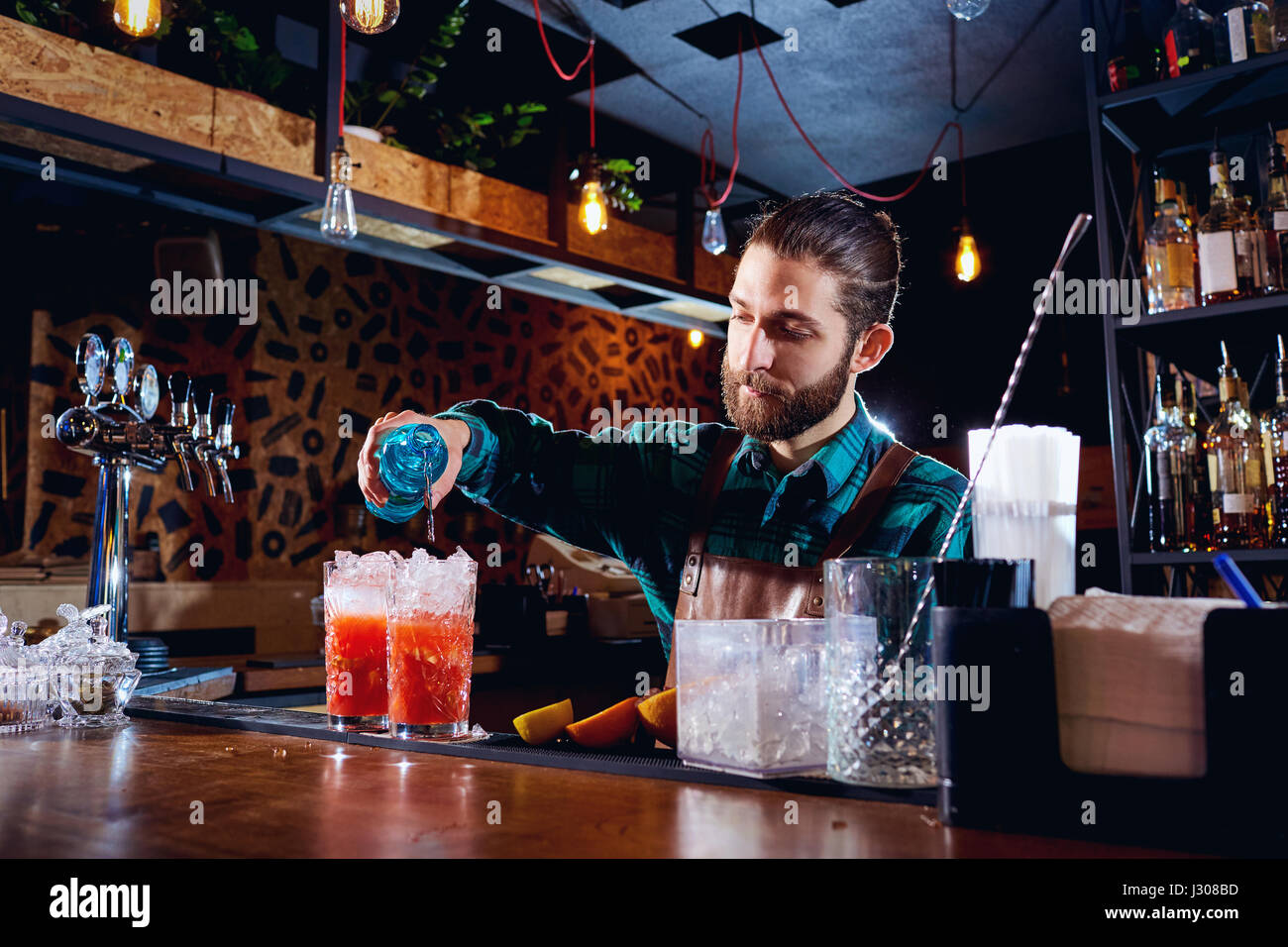 Il barista con la barba rende cocktail al bar Foto Stock