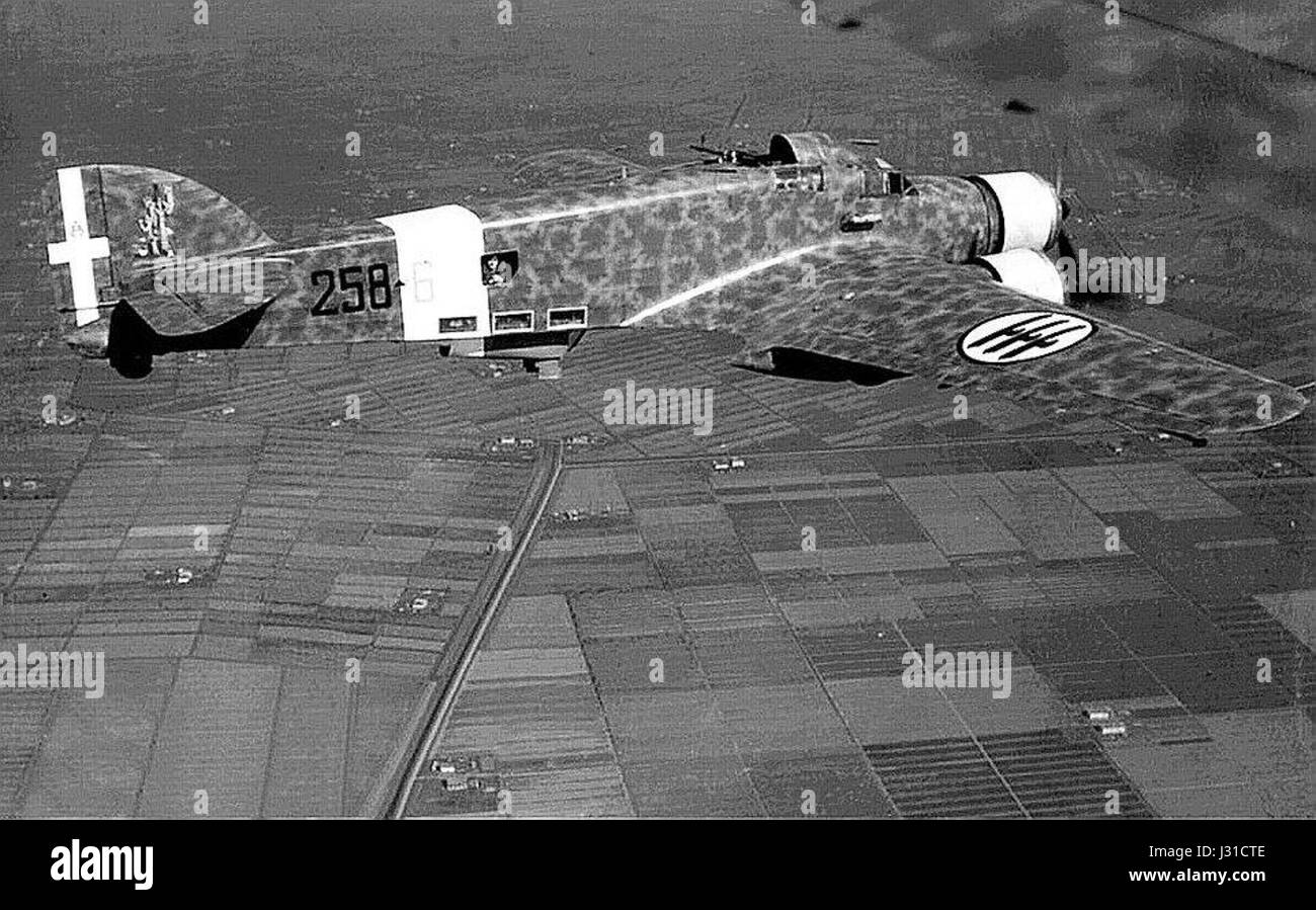 Il Savoia-Marchetti SM 79 Sparviero era un bombardiere italiano utilizzato durante la seconda guerra mondiale. Questa immagine mostra l'aereo che sorvola campi coltivati, simboleggiando il suo ruolo nella storia dell'aviazione militare. Foto Stock