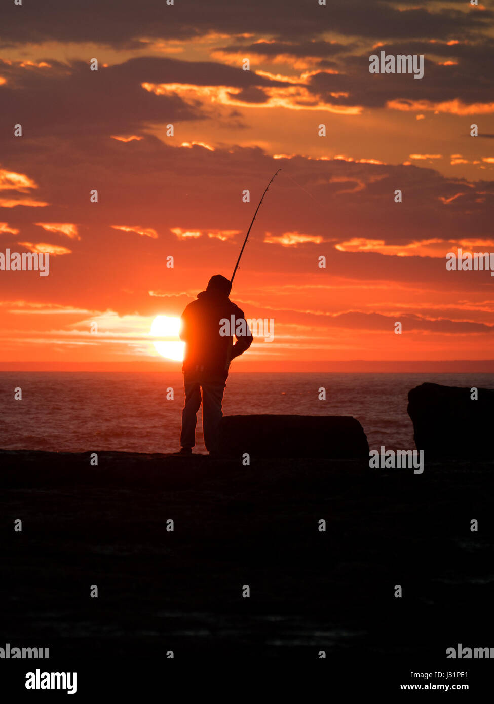 Portland, Dorset, Regno Unito. Il 1 maggio 2017. Pescatore alla fine della giornata con il sole che tramonta dietro. Credito/DTNews Alamy Live News Foto Stock