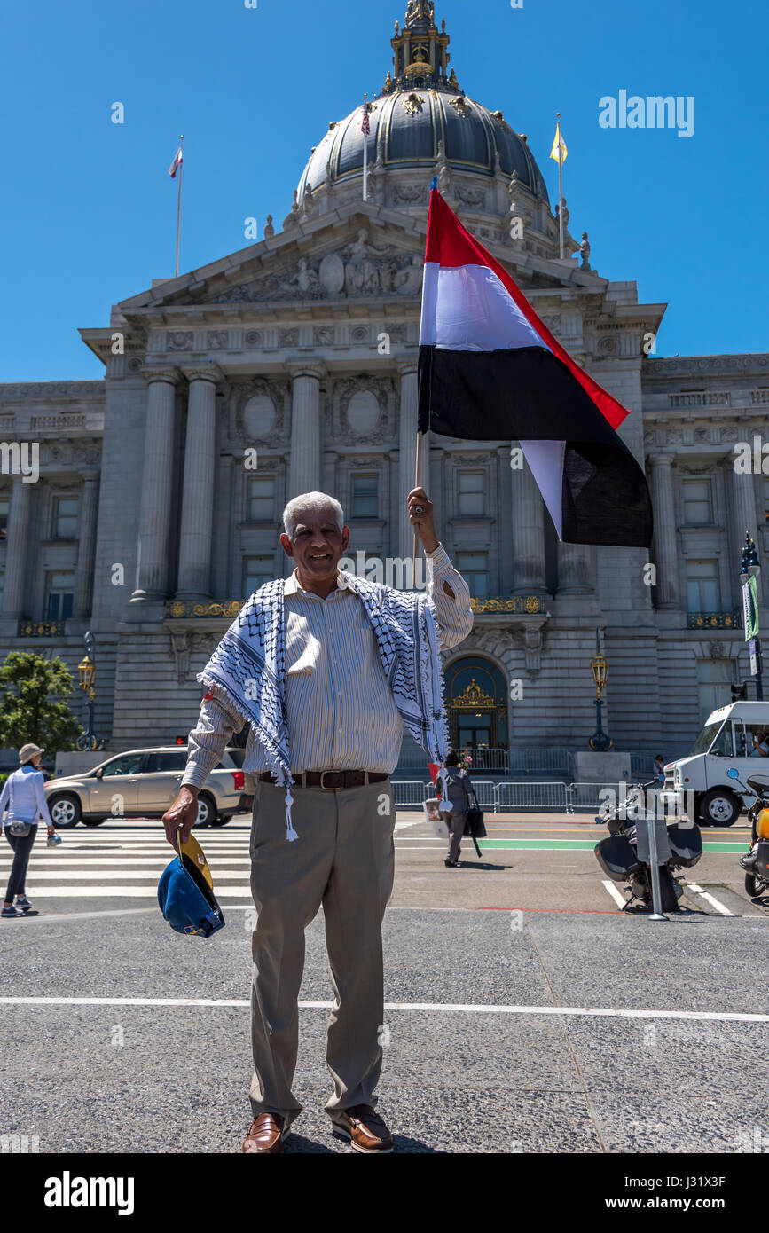 San Francisco, California, Stati Uniti d'America. Il 1 maggio, 2017. Un immigrato uomo si erge con orgoglio prima di San Francisco City Hall tiene la bandiera del suo nativo Yemen. Il 1 maggio 2017, più di 40 città in U.S.A. inscenato manifestazioni di protesta per il 'Day senza un immigrato.' a San Francisco da soli, migliaia sono scesi in piazza per protestare Trump's le politiche di immigrazione e di mostrare il proprio sostegno per i diritti degli immigrati. Credito: Shelly Rivoli/Alamy Live News Foto Stock