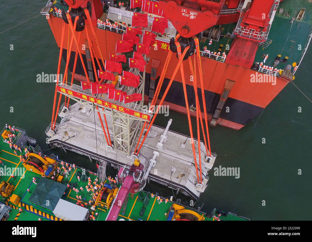 Zhuhai Zhuhai e Macao. Il 2 maggio, 2017. Una gigantesca gru, che è stato trasformato da una cisterna, paranchi a 6.000-ton struttura di tasto della più lunga del mondo cross-mare ponte che collega Hong Kong, Zhuhai e Macao, 2 maggio 2017. Il cuneo, dodici metri di lunghezza e pesa più di 25 Airbus A380 getti, è stata abbassata per collegare i tubi immersi del tunnel sotterraneo del ponte. Il 55-chilometro ponte collega Zhuhai nella provincia di Guangdong con Hong Kong e Macao. Esso include un 22,9-km Ponte e 6,7-km tunnel sotterraneo. Credito: Liu Dawei/Xinhua/Alamy Live News Foto Stock