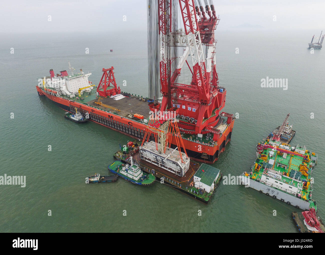 Zhuhai Zhuhai e Macao. Il 2 maggio, 2017. Una gigantesca gru, che è stato trasformato da una cisterna, paranchi a 6.000-ton struttura di tasto della più lunga del mondo cross-mare ponte che collega Hong Kong, Zhuhai e Macao, 2 maggio 2017. Il cuneo, dodici metri di lunghezza e pesa più di 25 Airbus A380 getti, è stata abbassata per collegare i tubi immersi del tunnel sotterraneo del ponte. Il 55-chilometro ponte collega Zhuhai nella provincia di Guangdong con Hong Kong e Macao. Esso include un 22,9-km Ponte e 6,7-km tunnel sotterraneo. Credito: Liu Dawei/Xinhua/Alamy Live News Foto Stock
