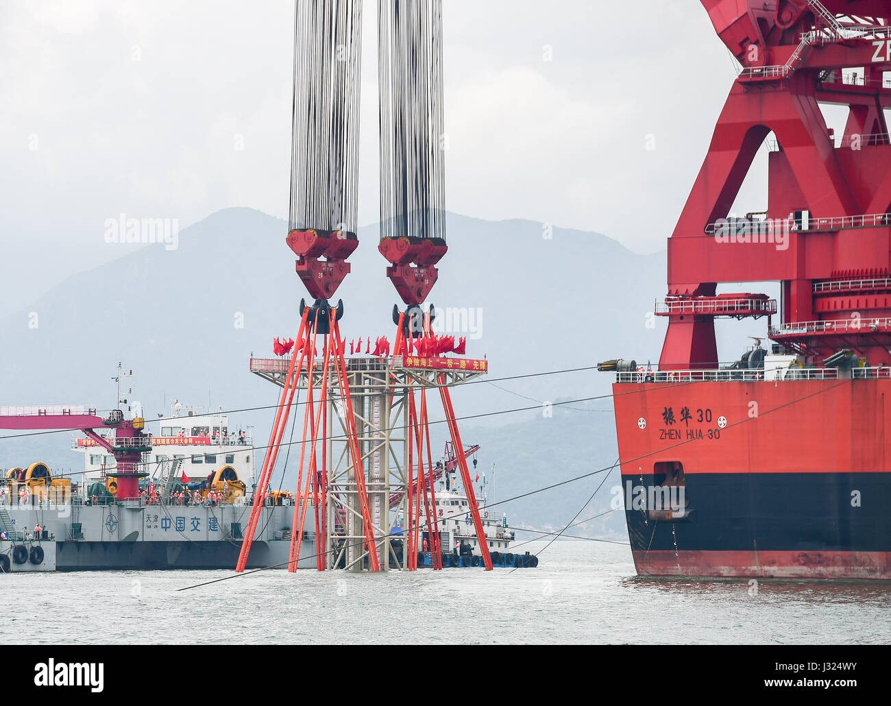 Zhuhai Zhuhai e Macao. Il 2 maggio, 2017. Una gigantesca gru, che è stato trasformato da una cisterna, installa un 6,000-ton struttura di tasto della più lunga del mondo cross-mare ponte che collega Hong Kong, Zhuhai e Macao, 2 maggio 2017. Il cuneo, dodici metri di lunghezza e pesa più di 25 Airbus A380 getti, è stata abbassata per collegare i tubi immersi del tunnel sotterraneo del ponte. Il 55-chilometro ponte collega Zhuhai nella provincia di Guangdong con Hong Kong e Macao. Esso include un 22,9-km Ponte e 6,7-km tunnel sotterraneo. Credito: Liu Dawei/Xinhua/Alamy Live News Foto Stock