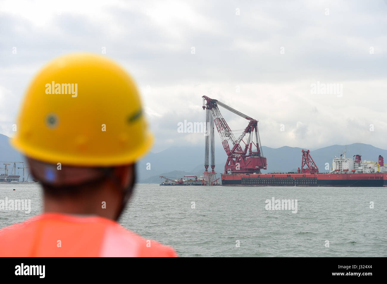 Zhuhai Zhuhai e Macao. Il 2 maggio, 2017. Una gigantesca gru, che è stato trasformato da una cisterna, installa un 6,000-ton struttura di tasto della più lunga del mondo cross-mare ponte che collega Hong Kong, Zhuhai e Macao, 2 maggio 2017. Il cuneo, dodici metri di lunghezza e pesa più di 25 Airbus A380 getti, è stata abbassata per collegare i tubi immersi del tunnel sotterraneo del ponte. Il 55-chilometro ponte collega Zhuhai nella provincia di Guangdong con Hong Kong e Macao. Esso include un 22,9-km Ponte e 6,7-km tunnel sotterraneo. Credito: Liu Dawei/Xinhua/Alamy Live News Foto Stock