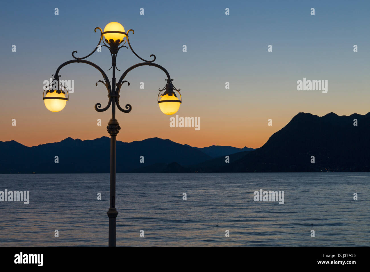 Lampione ornati sul lungolago con stupende vedute all'alba a Stresa Lago Maggiore in Italia nel mese di aprile Foto Stock