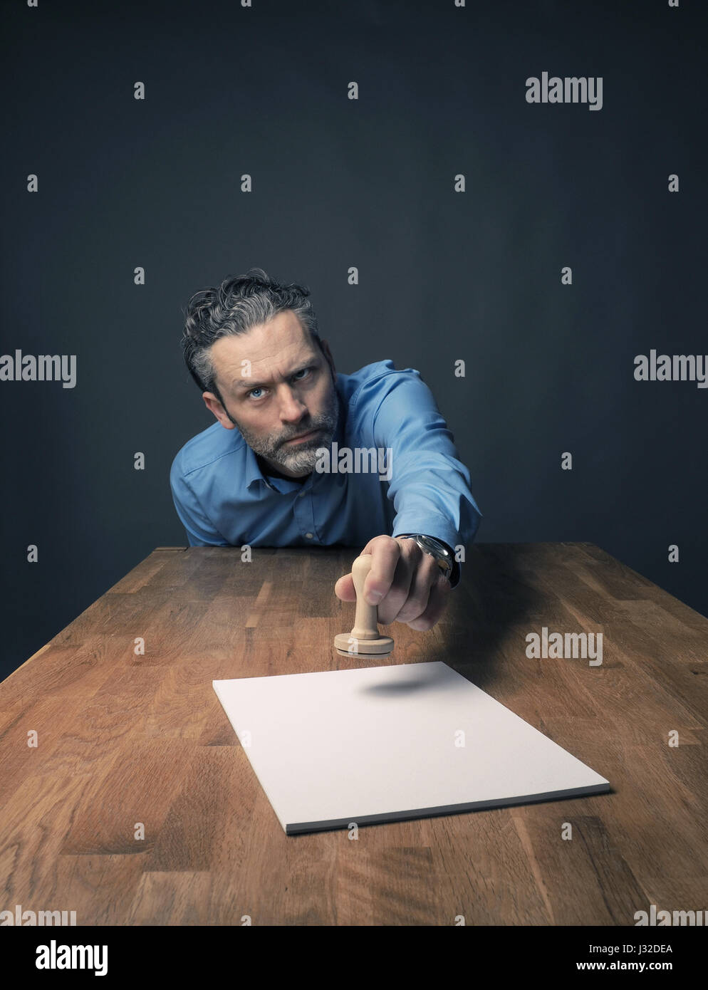 Uomo d'affari con un francobollo di legno, ampia angolazione Foto Stock