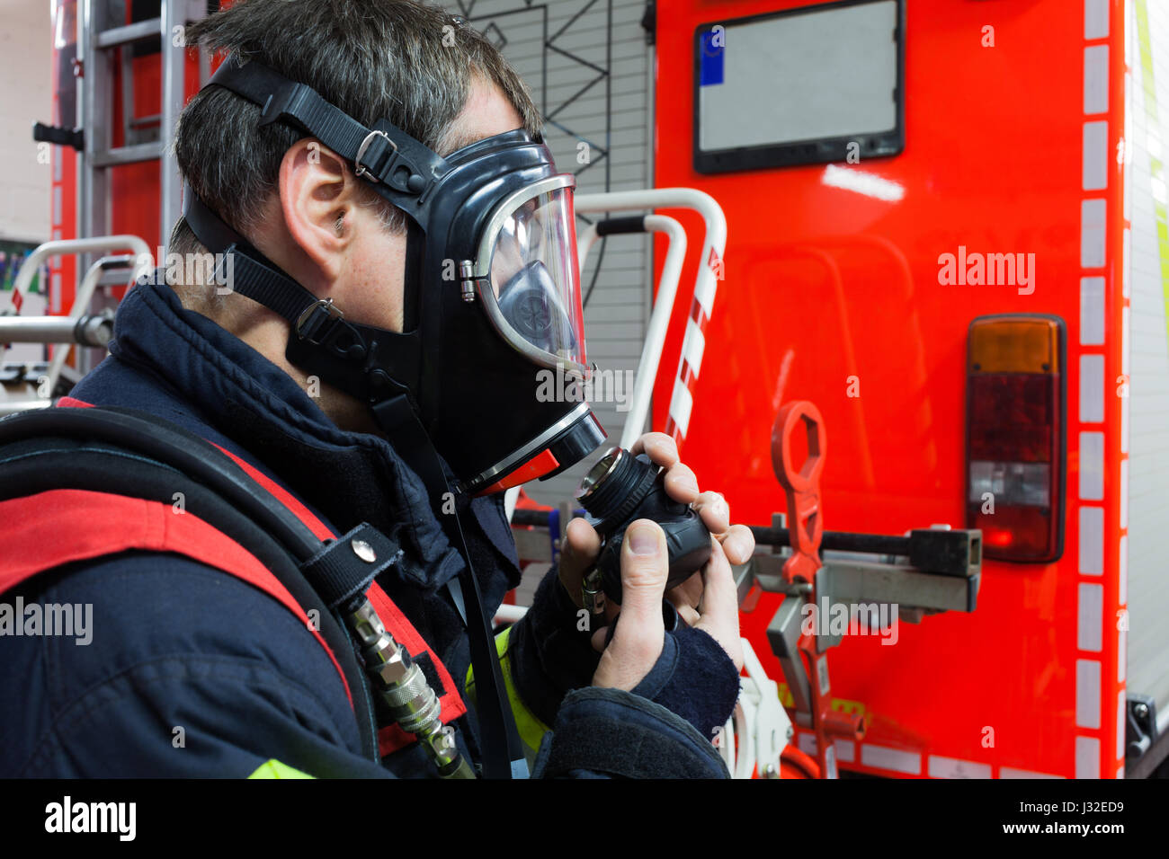 Vigile del fuoco tedesco con maschera in azione Foto Stock