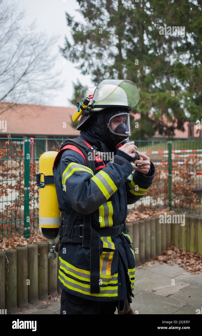 Vigile del fuoco tedesco outdoor in azione e con bottiglia di ossigeno e la maschera Foto Stock