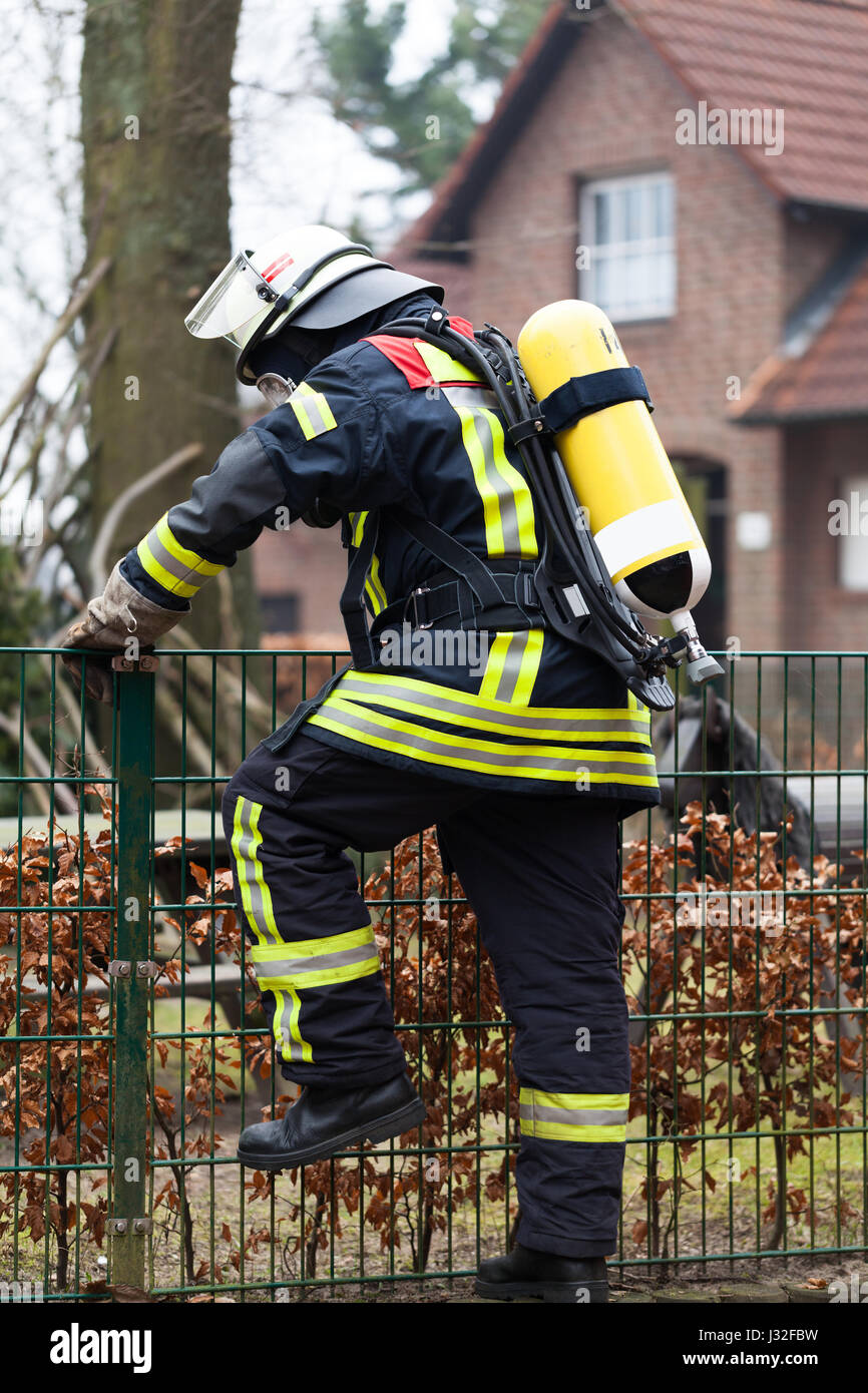 Vigile del fuoco tedesco outdoor in azione e con bottiglia di ossigeno e la maschera Foto Stock