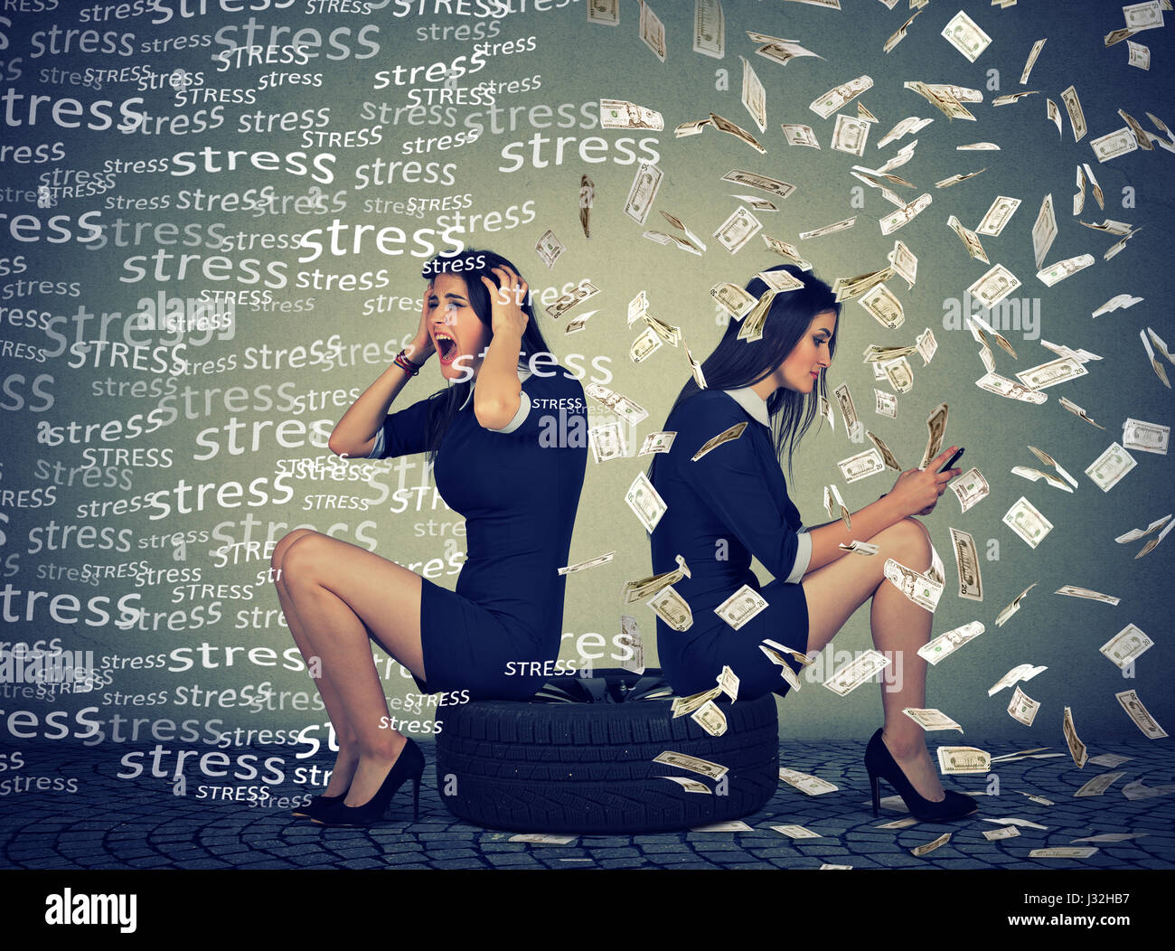 Due donne sedute su un pneumatico essendo ha sottolineato un altro successo utilizzando il telefono cellulare sotto la pioggia di denaro Foto Stock