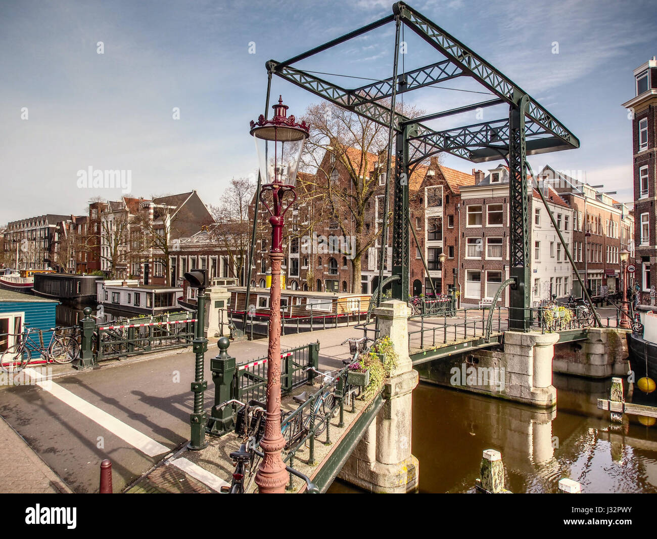 Questa fotografia cattura il Ponte 148 nella Binnen Dommersstraat che attraversa il Brouwersgracht, un canale di Amsterdam, raffigurante il paesaggio urbano e le caratteristiche architettoniche. Foto Stock