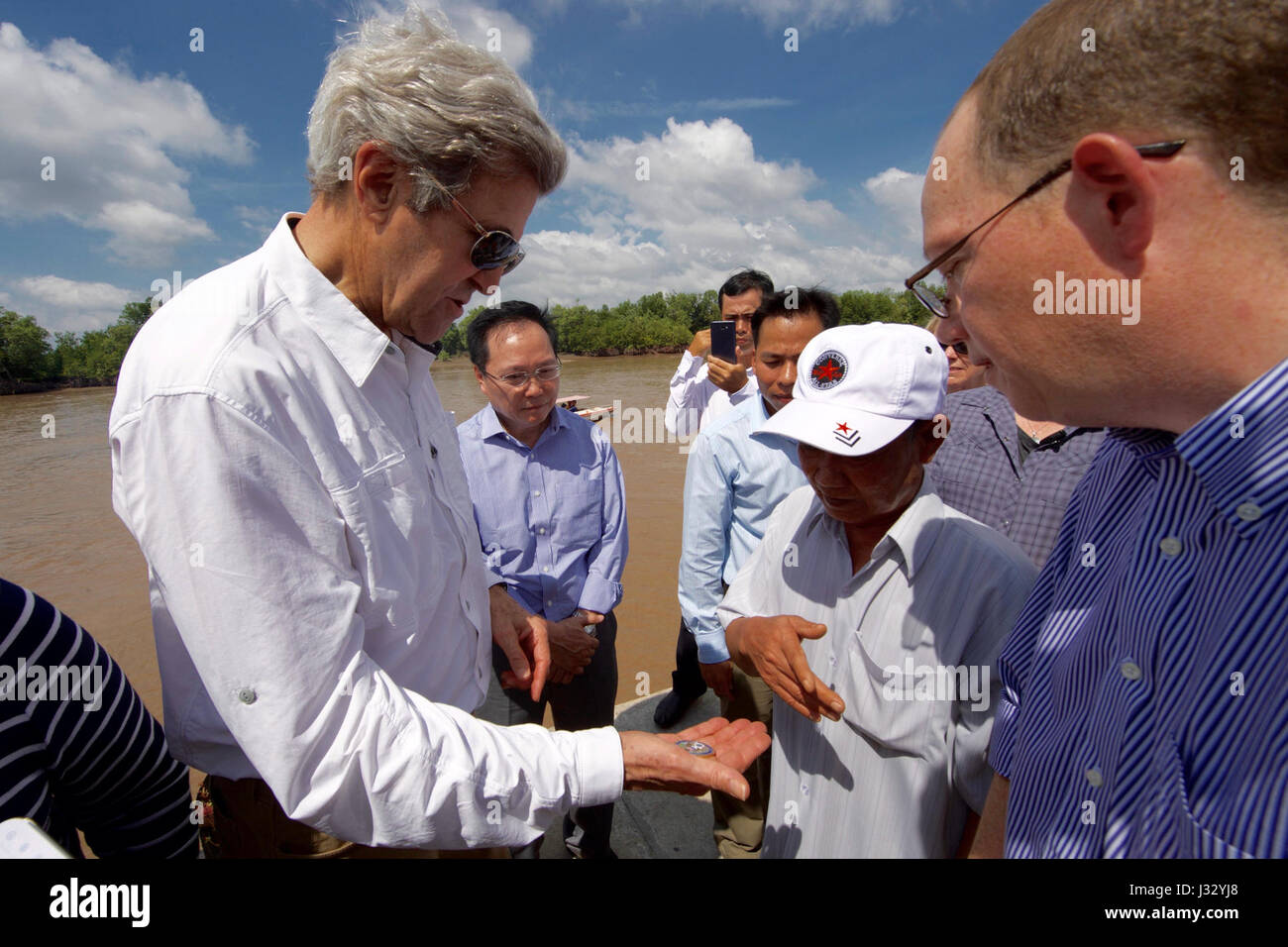 Il 14 gennaio 2017, il Segretario di Stato americano John Kerry ha presentato una moneta commemorativa Challenge Coin a Vo Ban Tam, un ex membro della squadra che ha attaccato la sua Swift Boat nel 1969, durante una visita a Nam CAN, in Vietnam. L'incontro si è verificato quando Kerry ha rivisitato le sue radici di servizio e ha appreso gli sforzi di riconciliazione e di mitigazione dei danni ambientali. Foto Stock