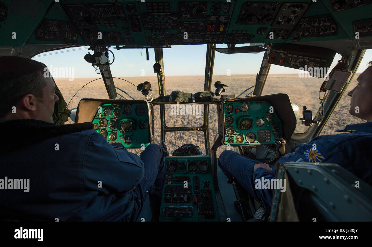Elicottero russo membri di equipaggio attendere nella cabina di pilotaggio di un MI-8 in corrispondenza della Soyuz MS-02 sito di atterraggio dopo il veicolo spaziale è atterrato con spedizione 50 comandante Shane Kimbrough della NASA e gli ingegneri di volo Sergey Ryzhikov e Andrey Borisenko di Roscosmos vicino alla città di Zhezkazgan, Kazakistan Lunedì, 10 aprile 2017 (kazako tempo). Kimbrough, Ryzhikov e Borisenko stanno ritornando dopo 173 giorni in uno spazio in cui essi sono serviti come membri della spedizione 49 e 50 equipaggi a bordo della Stazione Spaziale Internazionale. Photo credit: (NASA/Bill Ingalls) Foto Stock