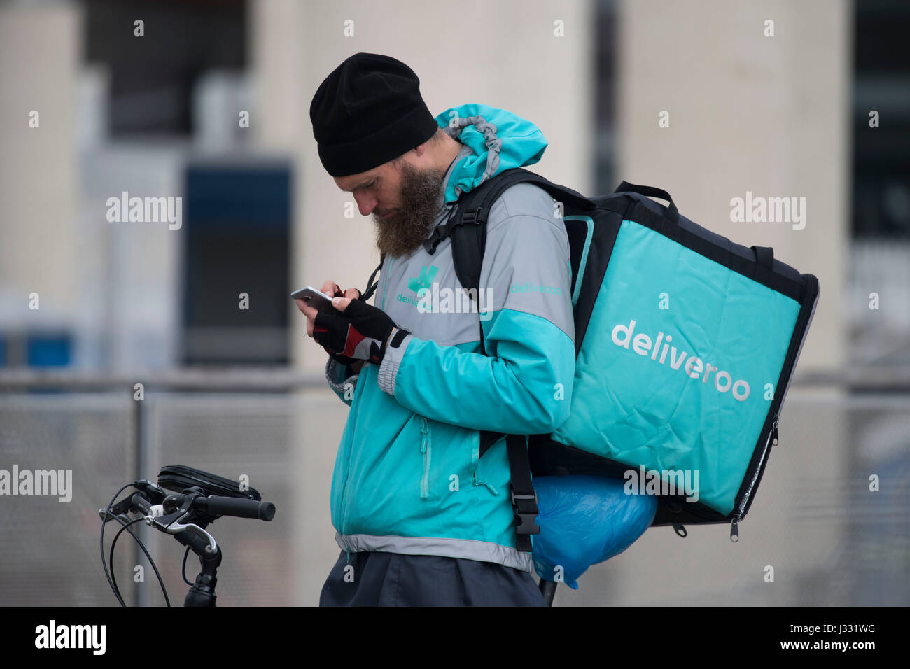 Un lavoratore Deliveroo su una bicicletta con un marchio Delivroo zaino  porta il cibo da asporto Foto stock - Alamy