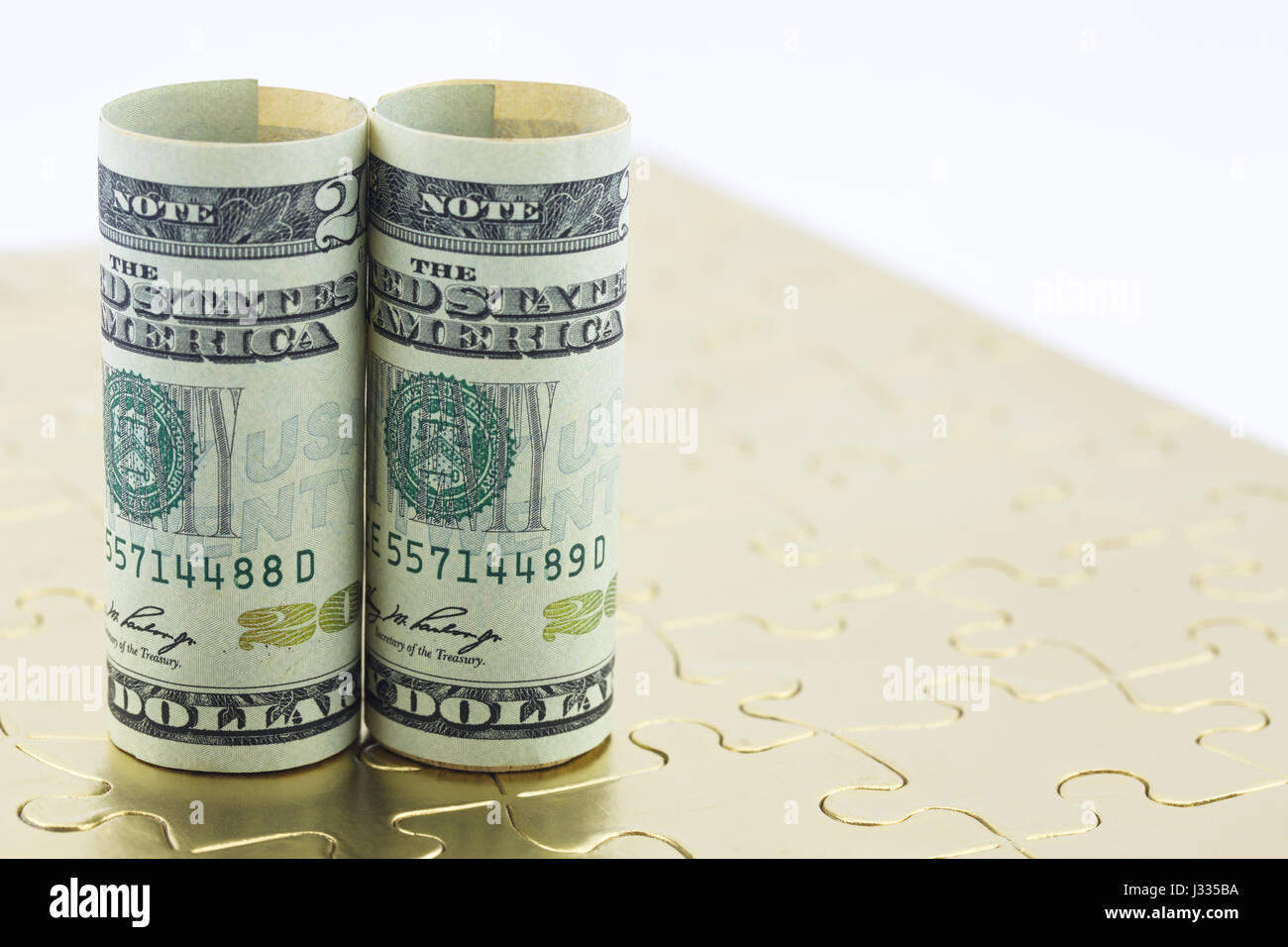 Dollari americani collocati in posizione verticale su oro puzzle riflettono la risoluzione vincente del commercio e degli investimenti dei problemi. Foto Stock