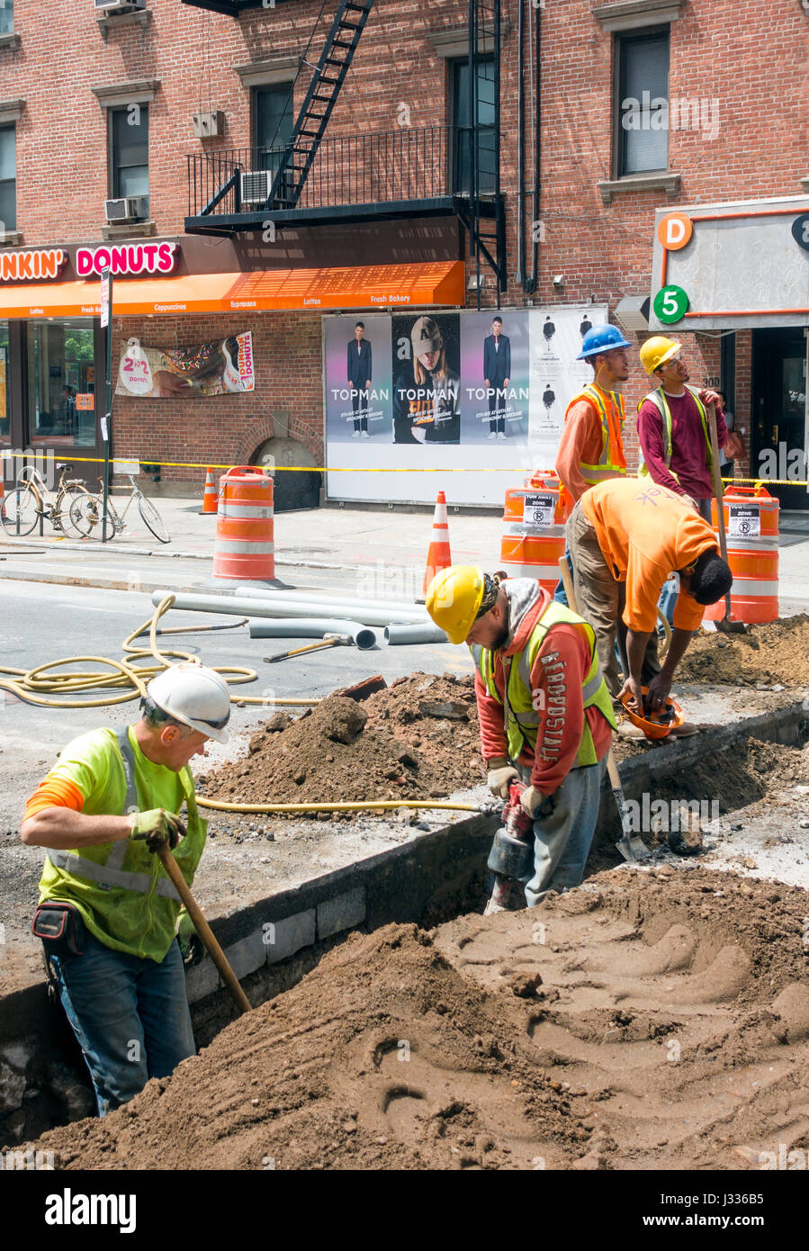 Un gruppo di lavoratori edili riparare le infrastrutture della metropolitana su una strada di Soho a New York City Foto Stock