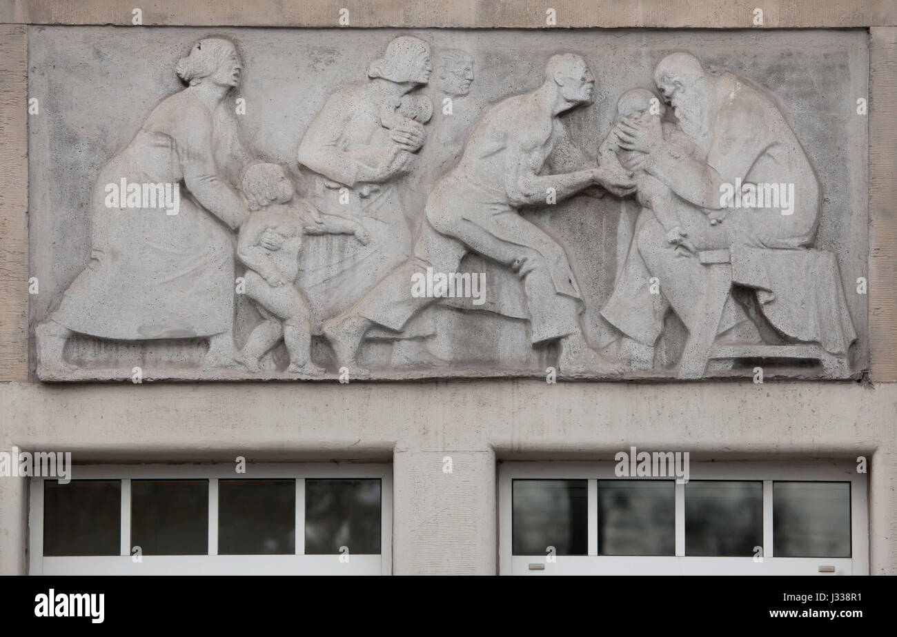 Allegoria della salute dei bambini. Sollievo da scultore ungherese Mihaly Biro sull'ala sud dell'edificio in Art Nouveau di Budapest - i lavoratori del fondo di assicurazione in Budapest, Ungheria. L'edificio, ora utilizzato come sede dell'Assicurazione Sociale Nazionale Centro (OTI), è stato progettato da architetti ungheresi Komor Marcell e Jakab Dezso e costruito nel 1913. L'ala nord è stato aggiunto nel 1930s. Foto Stock