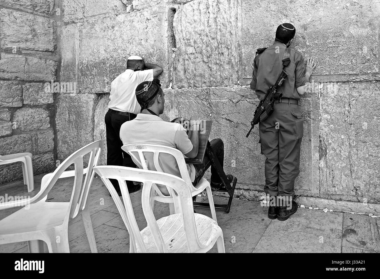 Soldato e altri due uomini in preghiera al Muro Occidentale di Gerusalemme, Israele Foto Stock