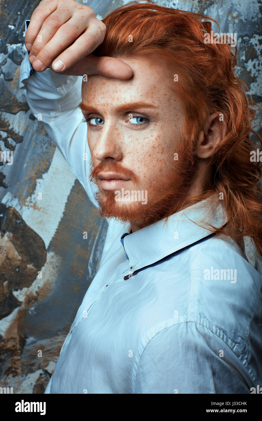 I capelli rossi con barba e baffi in una camicia bianca metrosexual. Foto Stock