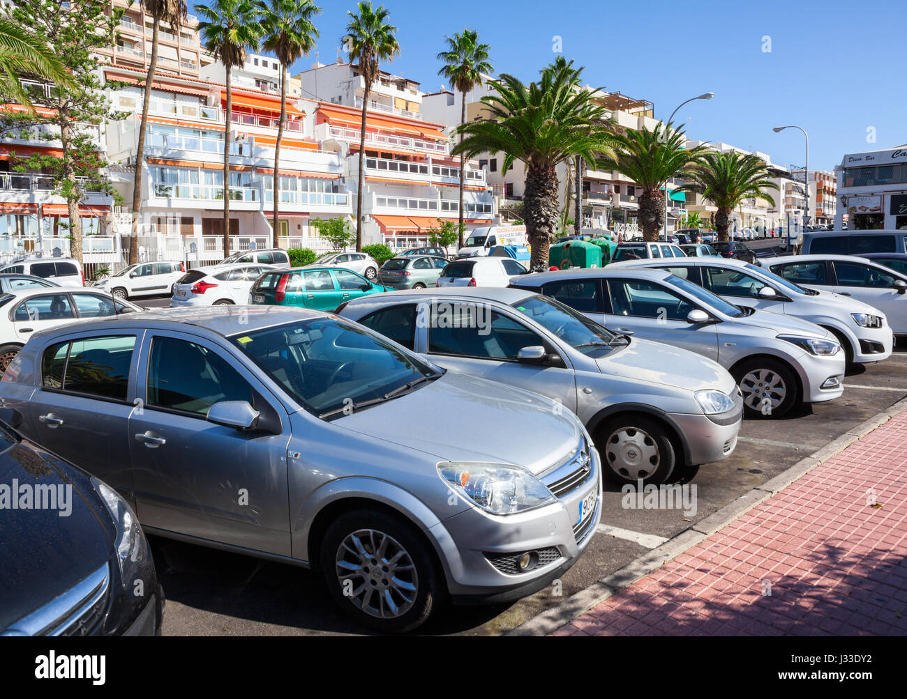 Di Los Cristianos, Tenerife, SPAGNA - Circa gen, 2016: pieno di veicoli nelle aree di parcheggio sono in via di resort city vicino alla spiaggia. Alta stagione estiva Foto Stock