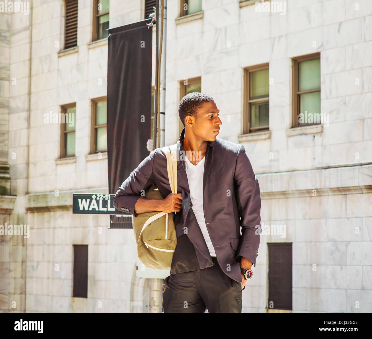 Street Fashion. Giovane americano africano uomo che viaggia in New York,  vestita di nero elegante giacca camicia bianca, orologio da polso,  trasporto borsa a tracolla, s Foto stock - Alamy