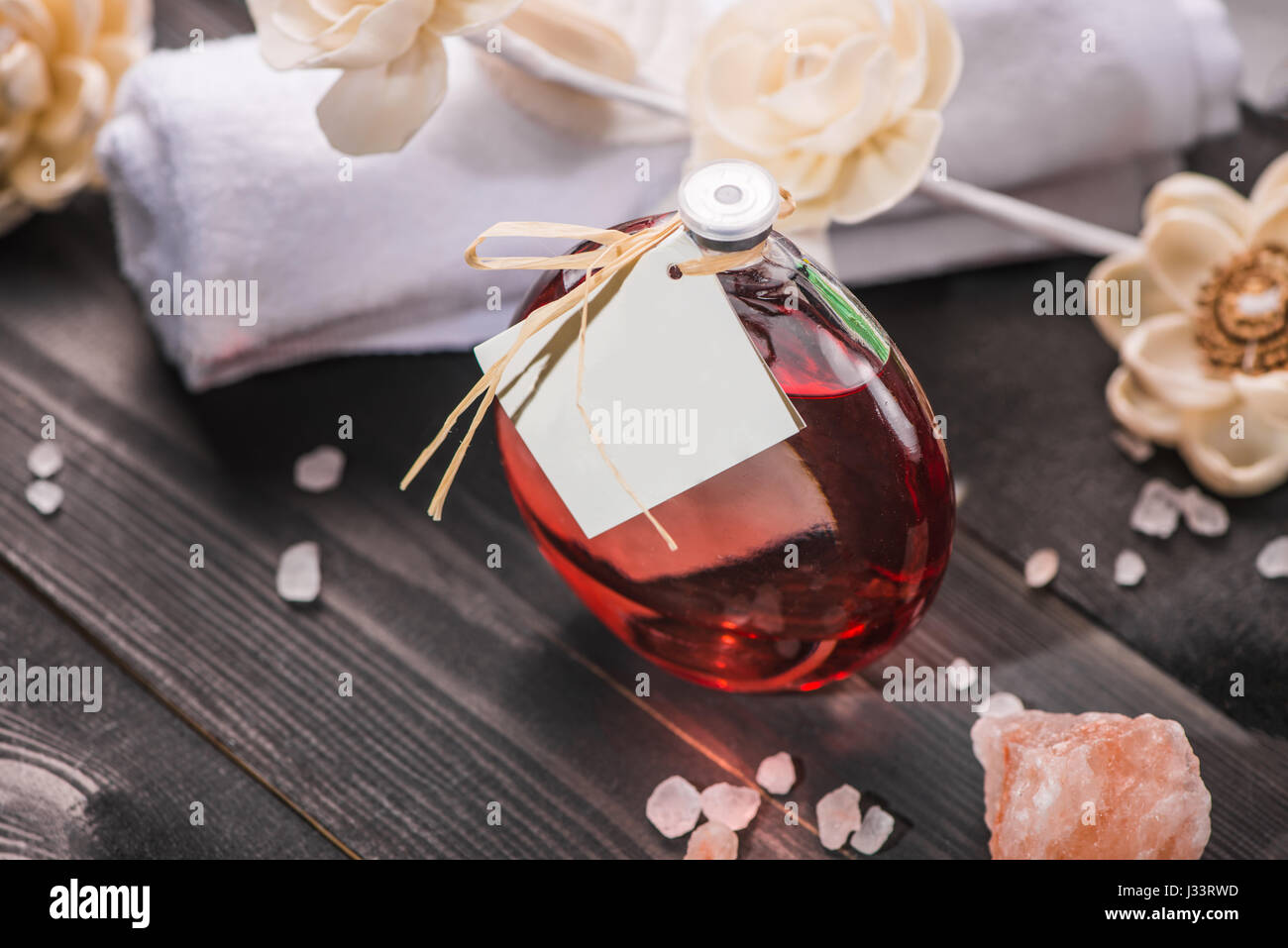 Spa decorazione. Bottiglia di olio essenziale e progetto di fiori. Foto Stock