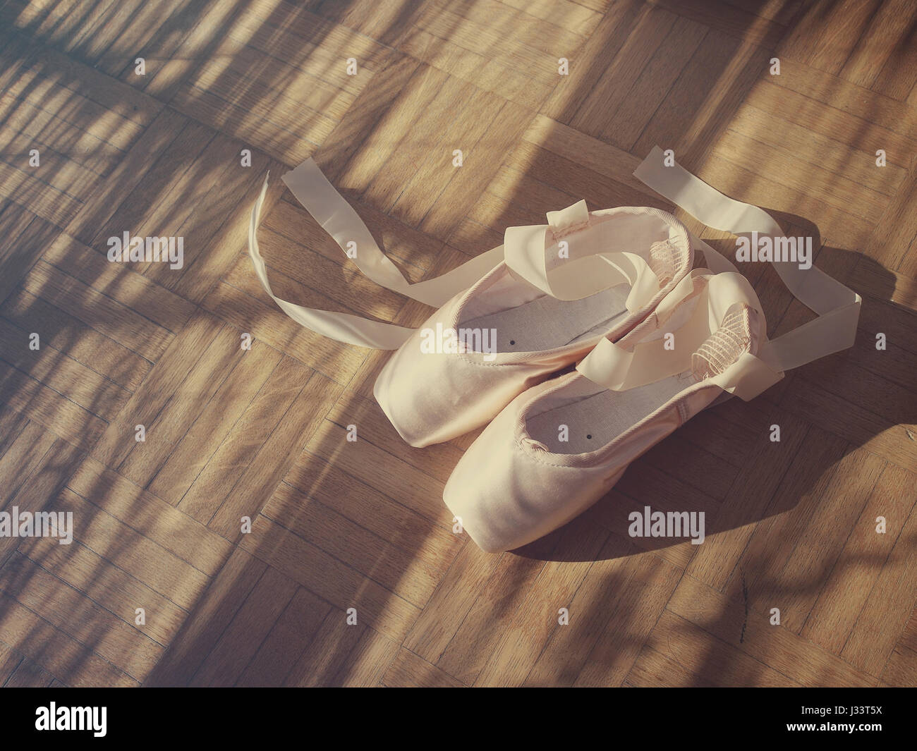 Scarpe da ballo e nastri su un pavimento di legno. Foto Stock