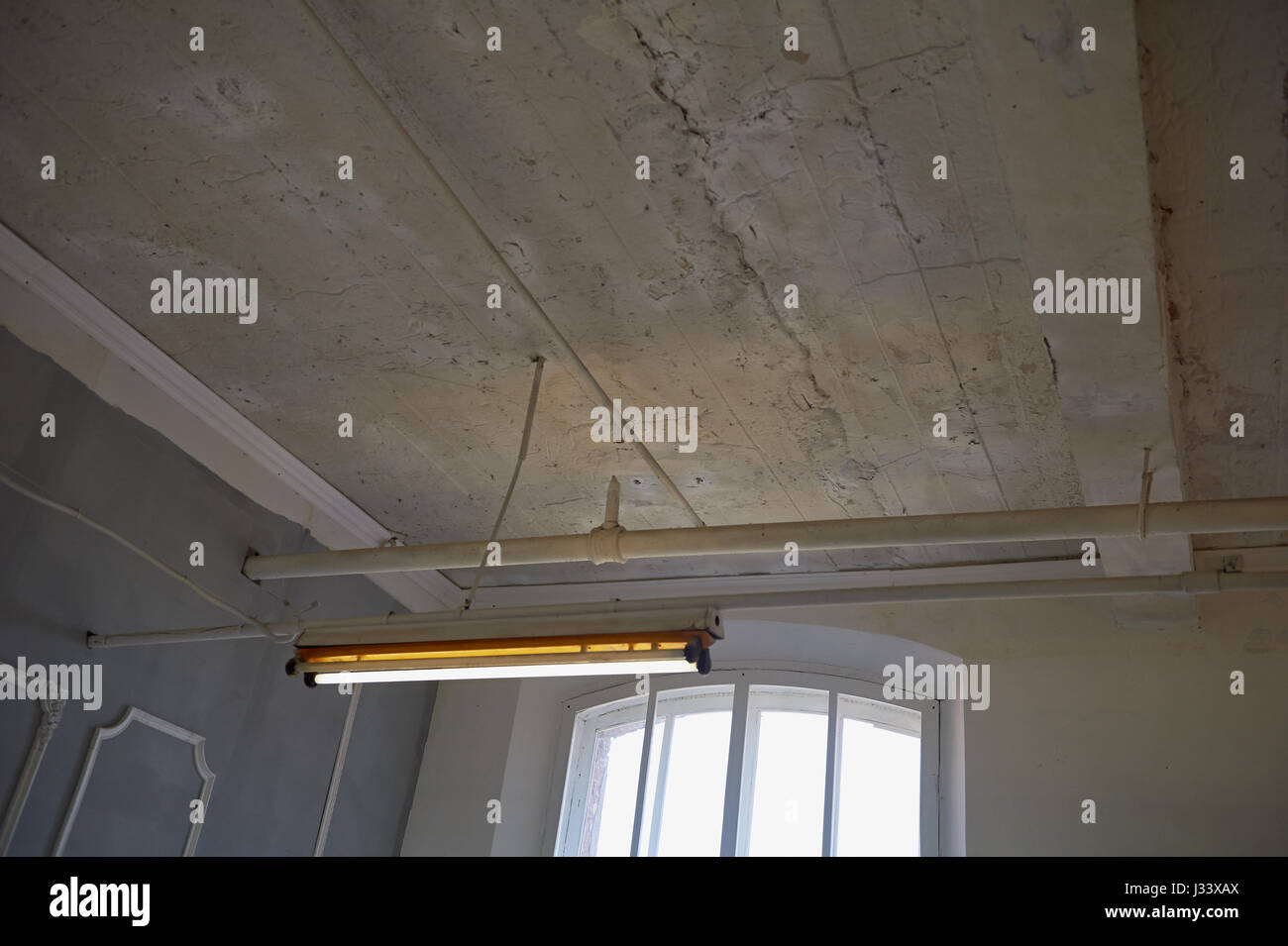 Il vecchio soffitto bianco nella fabbrica di produzione edificio con tettuccio di luci fluorescenti Foto Stock