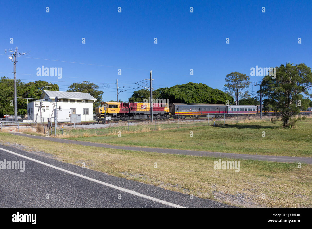 Alimentati a diesel treno passeggeri approachnig passaggio a livello nel Queensland, Australia Foto Stock