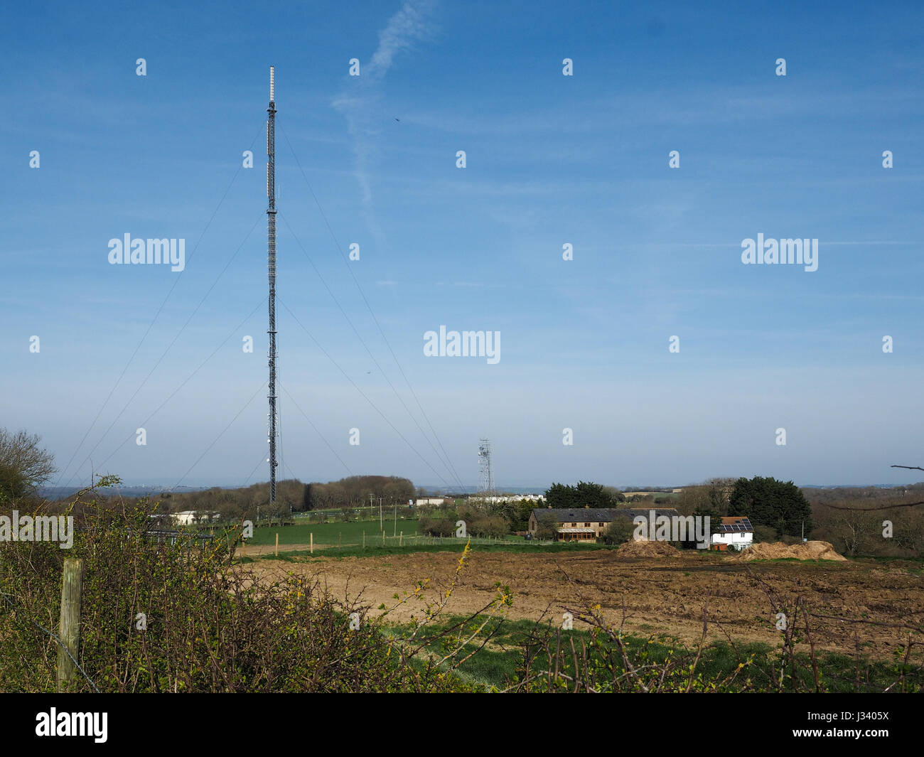 Un alto antenna antenna in campagna sotto il cielo blu Foto Stock