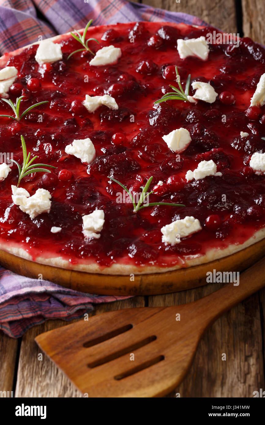 Pizza con salsa di mirtilli, formaggio di capra e rosmarino vicino sul piano verticale. Foto Stock