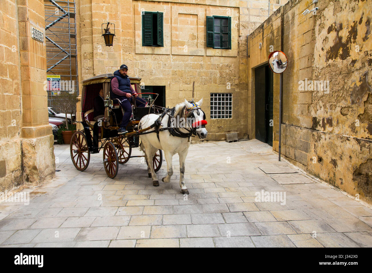 Gli ospiti possono noleggiare un carrello per esplorare gli affascinanti fortificata città medioevale di Mdina, Malta. Foto Stock