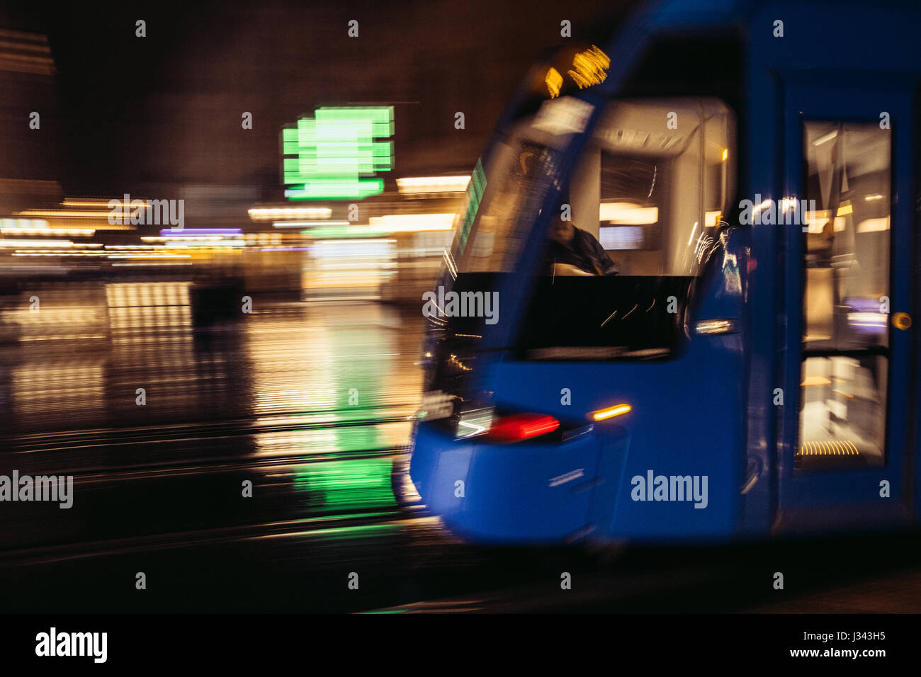 Sfocato il tram che si muove attraverso un umide e piovose del centro della città di Cracovia, in Polonia. I mezzi di trasporto pubblici motion blur applicato nella fotocamera. Foto Stock