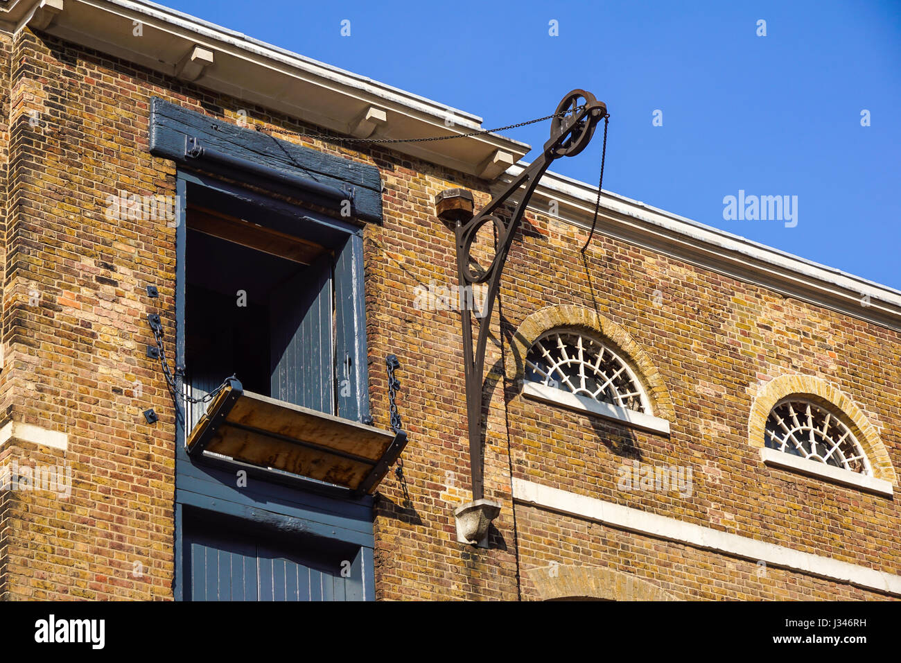 Dettaglio del vecchio edificio in mattoni in Inghilterra con porte di carico Foto Stock