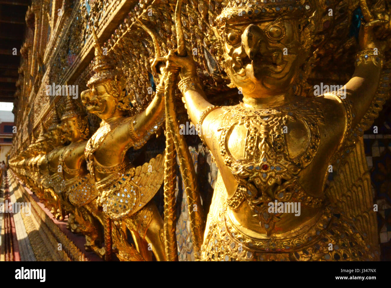 Vista in prospettiva all'interno dell'Imperial Grand Palace a Bangkok, in Thailandia. Essa mostra uno dei loro guardiani del cielo e la popolazione di uccelli, realizzato in oro Foto Stock