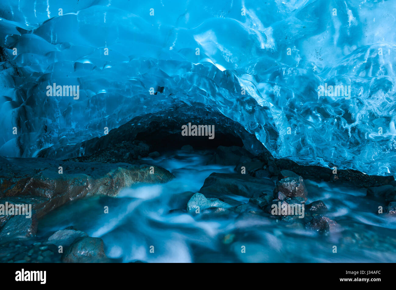 Una caverna di ghiaccio, formata sotto il ghiacciaio Vatnajokull (uno dei  più grandi ghiacciai del mondo) bagnata dal blu elettrico colore del  ghiacciaio Foto stock - Alamy