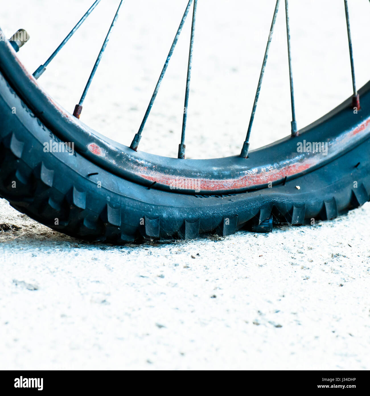Una gomma piatta su una bicicletta abbandonata. Foto Stock