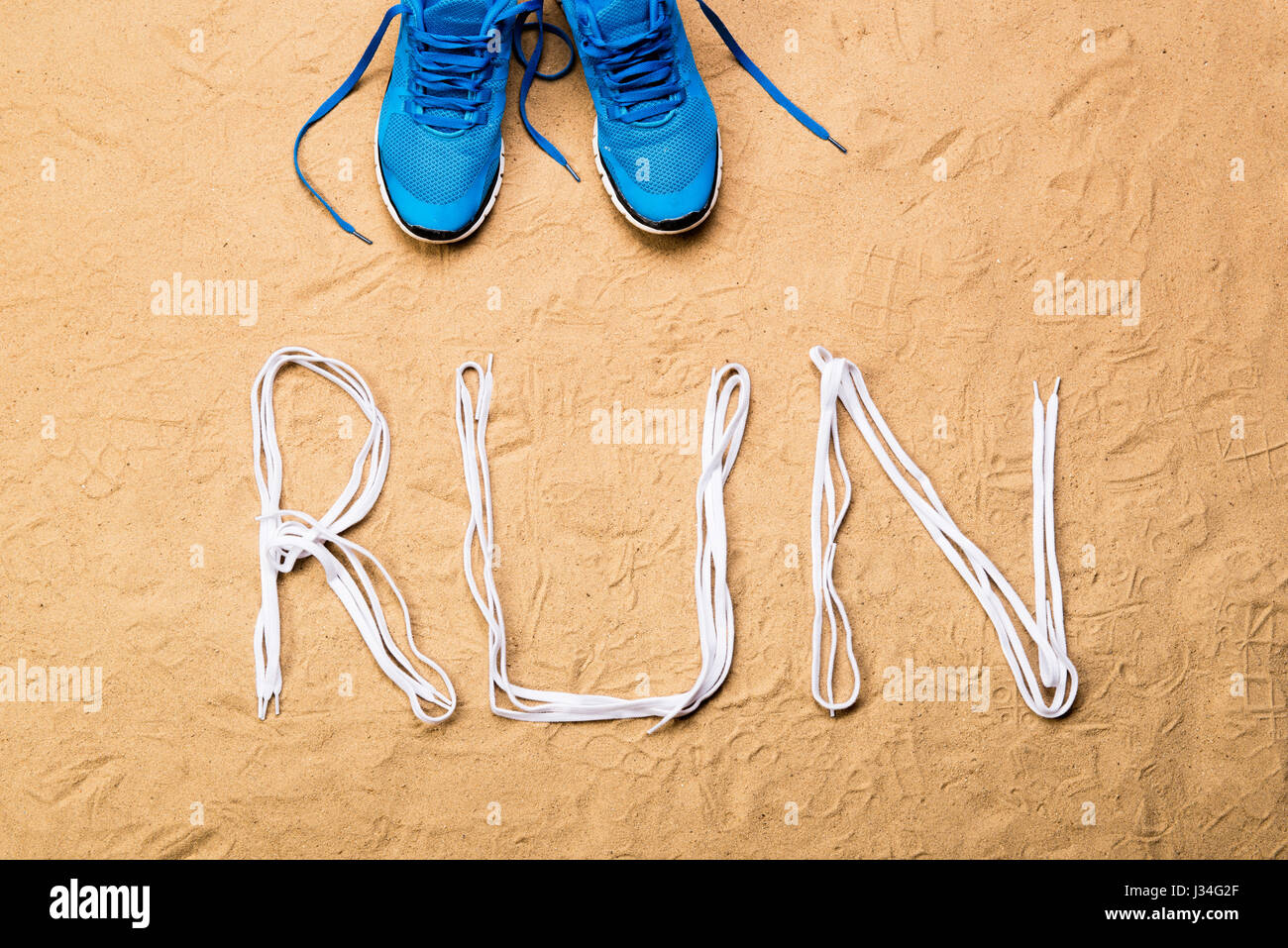 Scarpe da corsa e di eseguire il segno fatto di lacci delle scarpe, sabbia Foto Stock