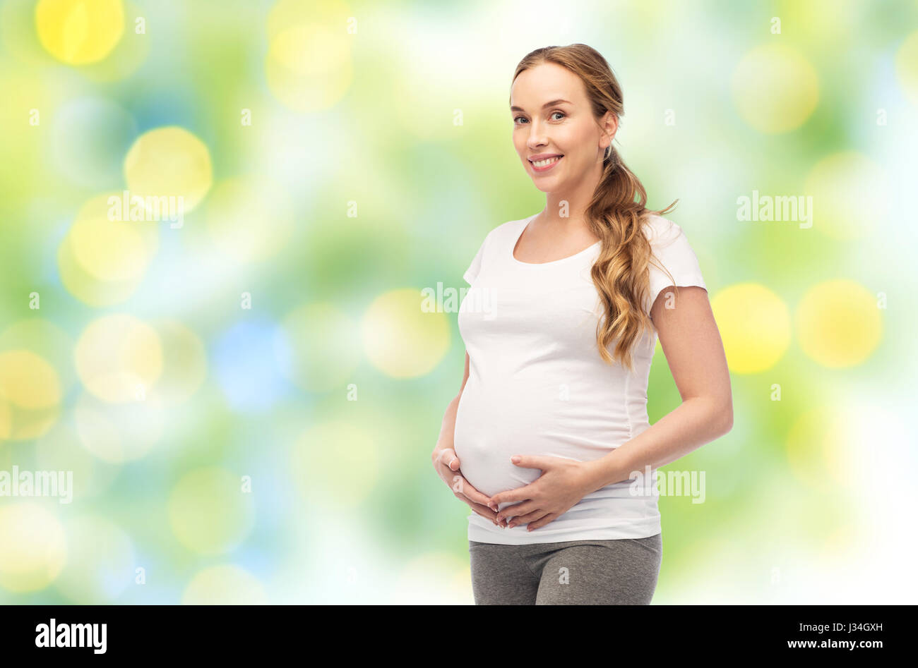 Felice donna incinta di toccare la sua grande pancia Foto Stock