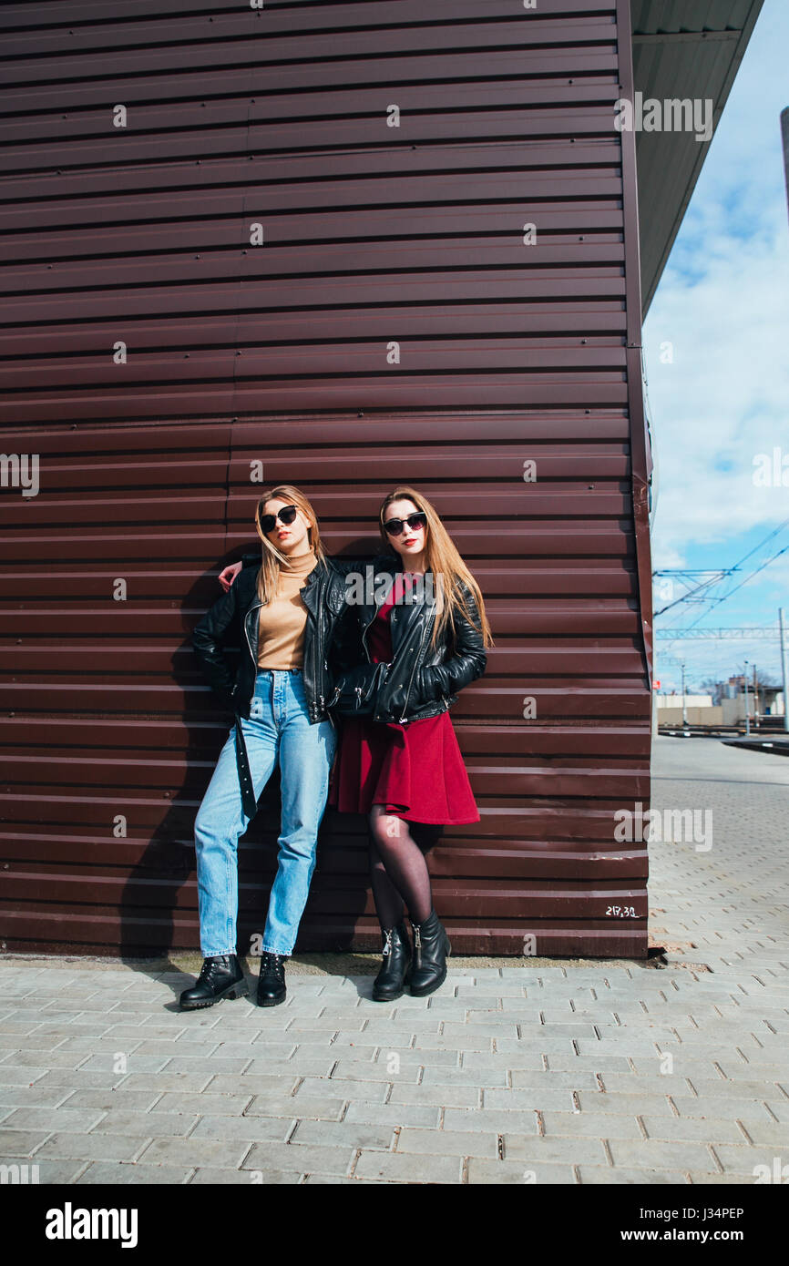 Conversazione tra due donne nella città.Outdoor Lifestyle ritratto di due migliori amici hipster ragazze indossano Elegante giacca di pelle e occhiali da sole, going crazy e avente un grande tempo insieme Foto Stock
