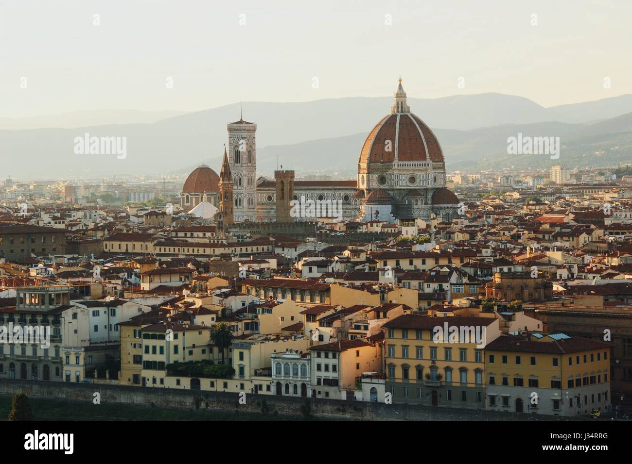 Elevata guarda Firenze centro città dominata dalla cattedrale di Santa Maria del Fiore con le montagne sullo sfondo al tramonto Foto Stock