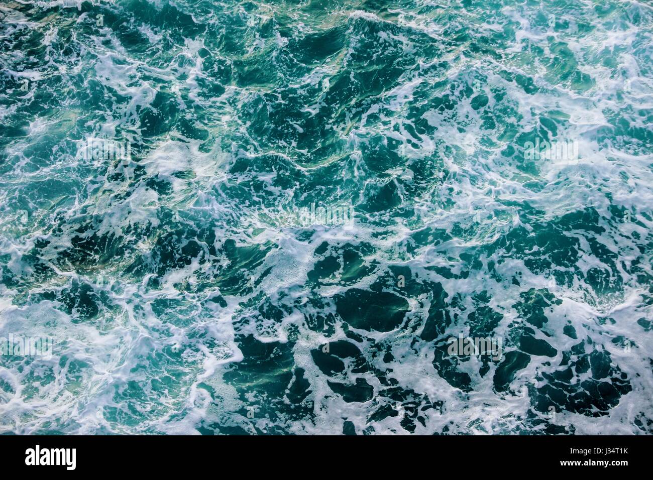 Schiumoso acqua di mare sotto le scogliere di spagnolo costa settentrionale Foto Stock
