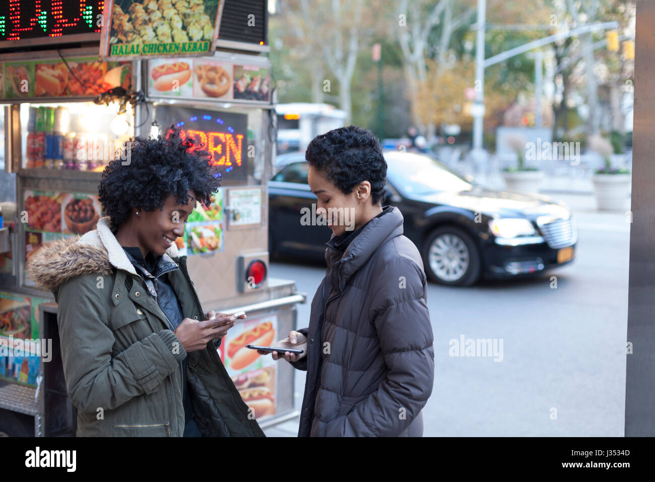 Giovani donne di controllare i loro telefoni intelligenti Foto Stock