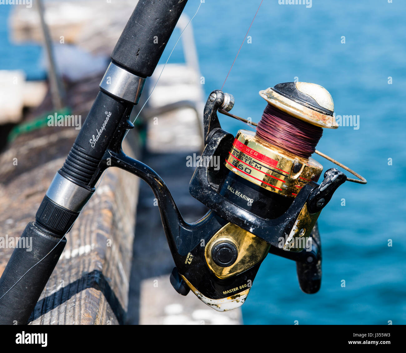 Un buon uso di un mulinello da pesca sul molo presso la spiaggia di Venezia, Los Angeles, CA, Stati Uniti d'America Foto Stock