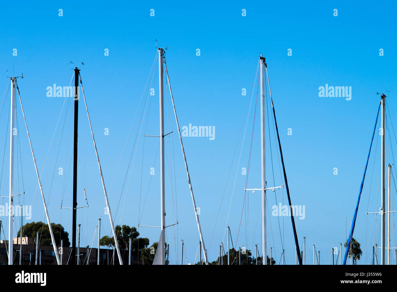 Gli alberi delle barche a vela parcheggiate rendono i modelli contro il cielo. Foto Stock