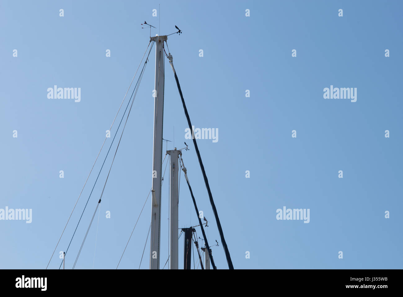 Gli alberi delle barche a vela parcheggiate rendono i modelli contro il cielo. Foto Stock