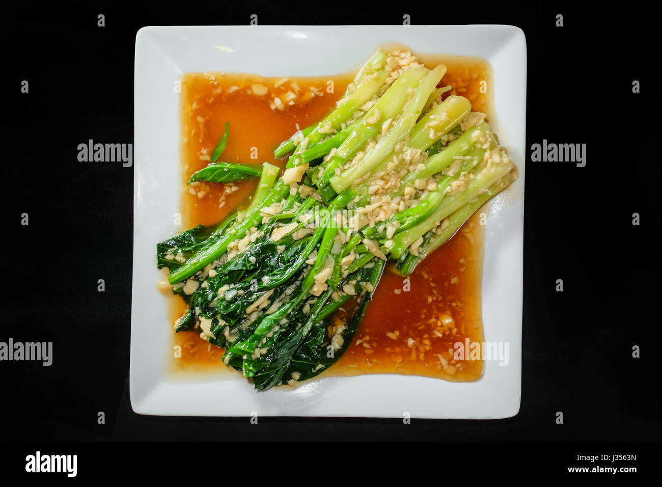 Broccoli cinesi con la salsa di ostriche in sfondo nero Foto Stock